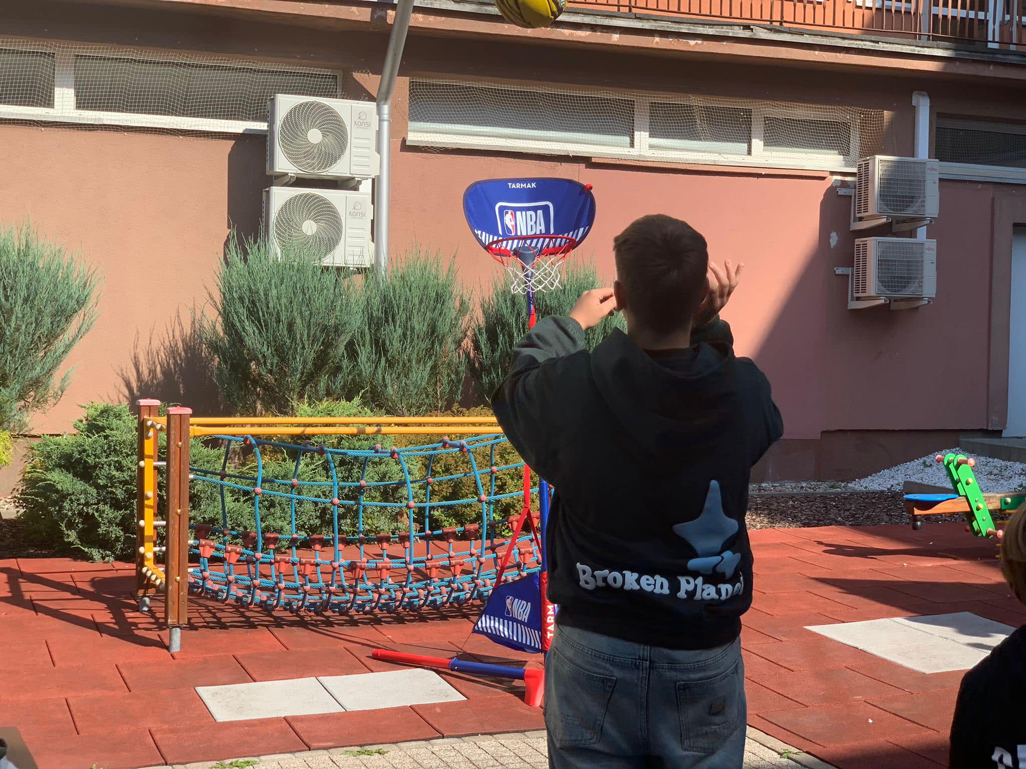 chłopiec gra w koszykówkę na patio szpitalnym