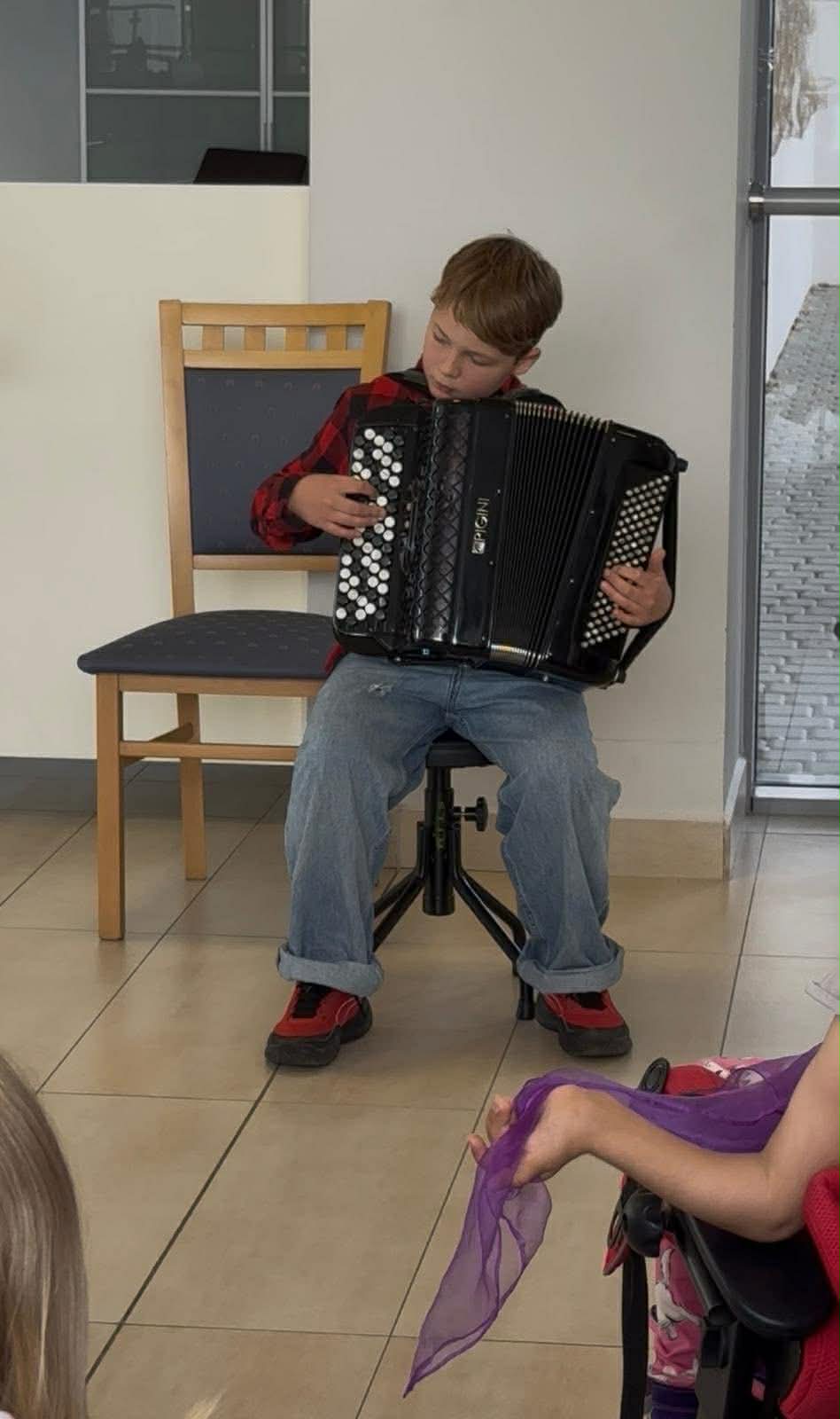 chłopiec grający na akordeonie