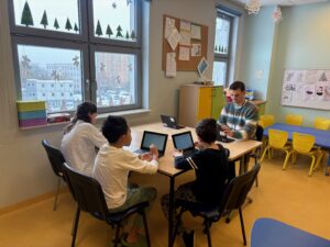 na obrazku są uczniowie oraz prowadzący zajęcia z wręczonymi tabletami